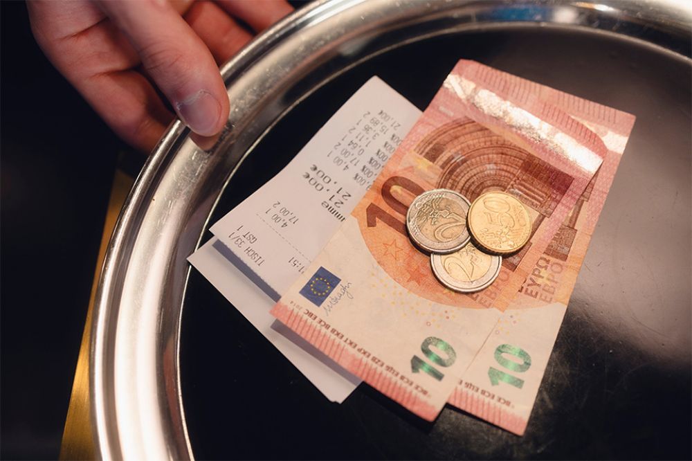 Foto: Silbernes Tablett mit Trinkgeld und Rechnung darauf